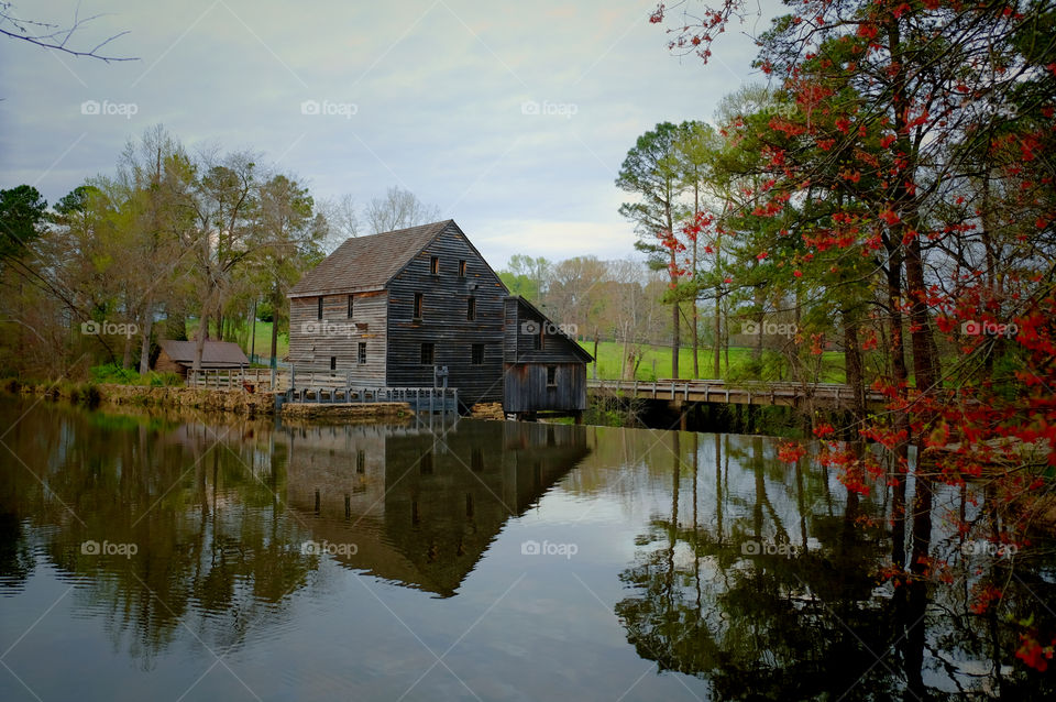 The old gristmill or watermill across the millpond during spring at Yates Mill County Park in Raleigh North Carolina, Triangle area, Wake County. 