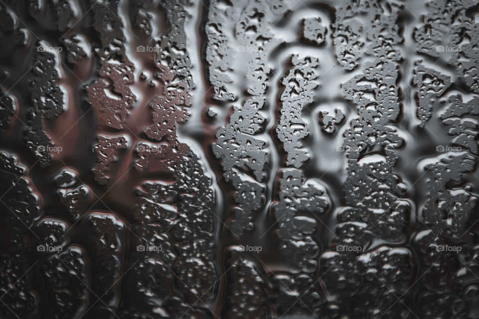 Droplets on a bus window glass, it was hard rain in a city and I love the texture and shape the droplets made