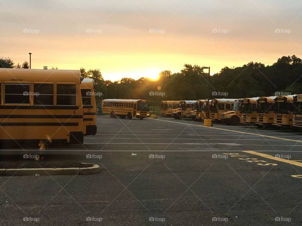 It's back to school time! A fleet of buses prepares to pick up children as they sit in the kitchen eating breakfast.