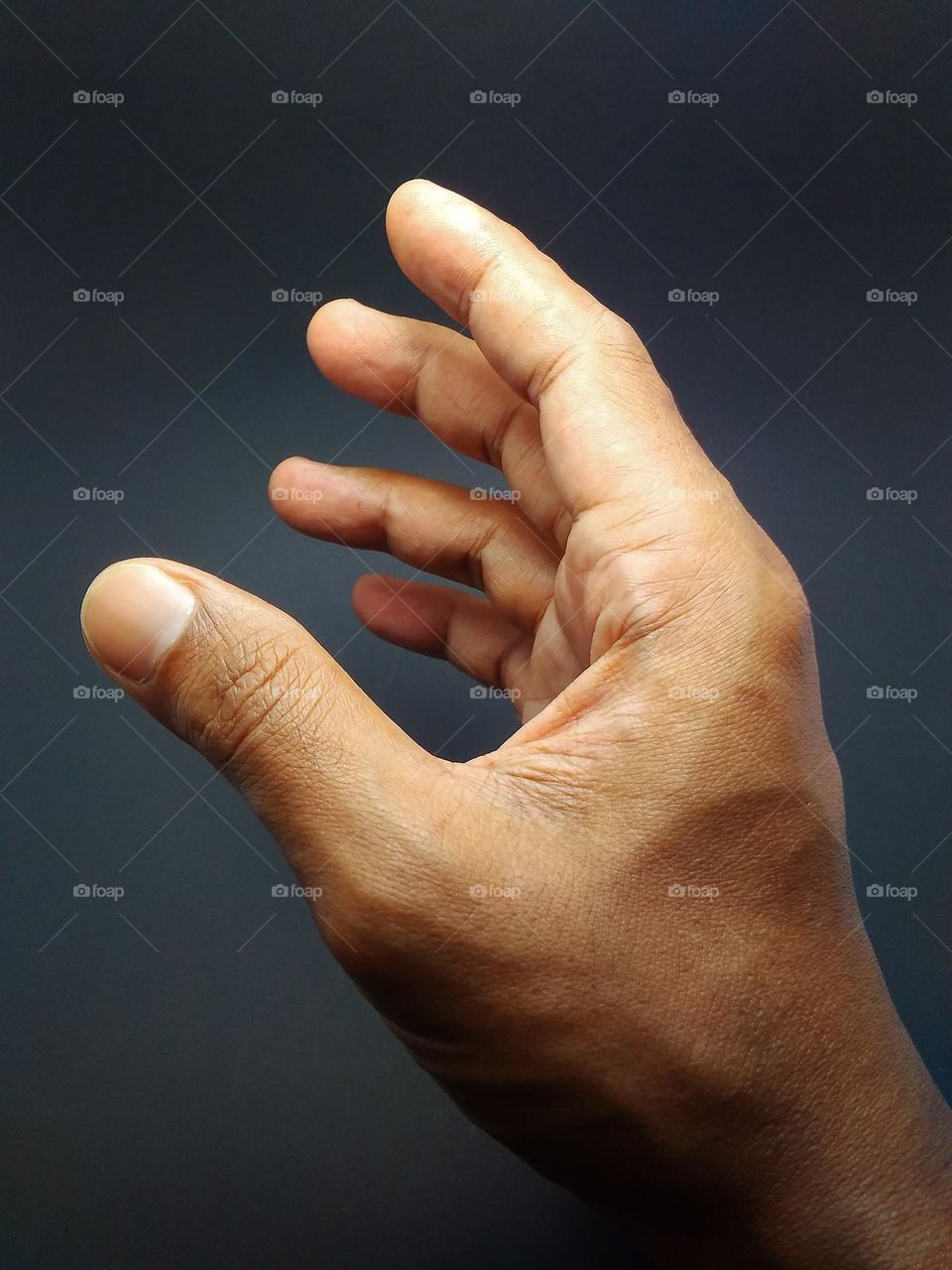 human hand and fingers in close-up photo in studio on black background.