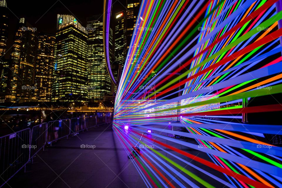 Light display using coloured tapes and UV light in the evening in Singapore with buildings in background