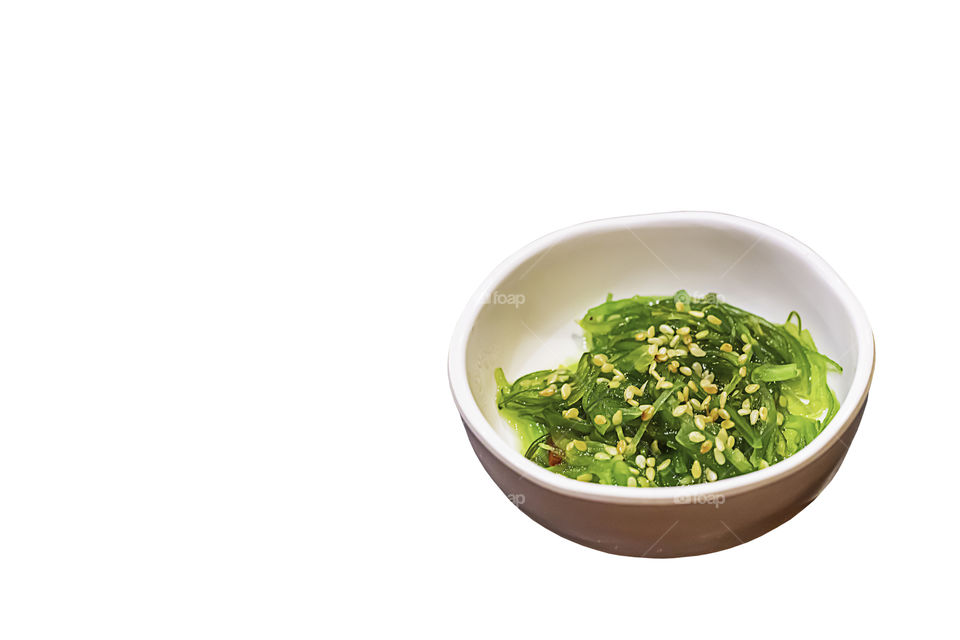 Wakame seaweed and sesame seeds in cup  on a white background with clipping path.