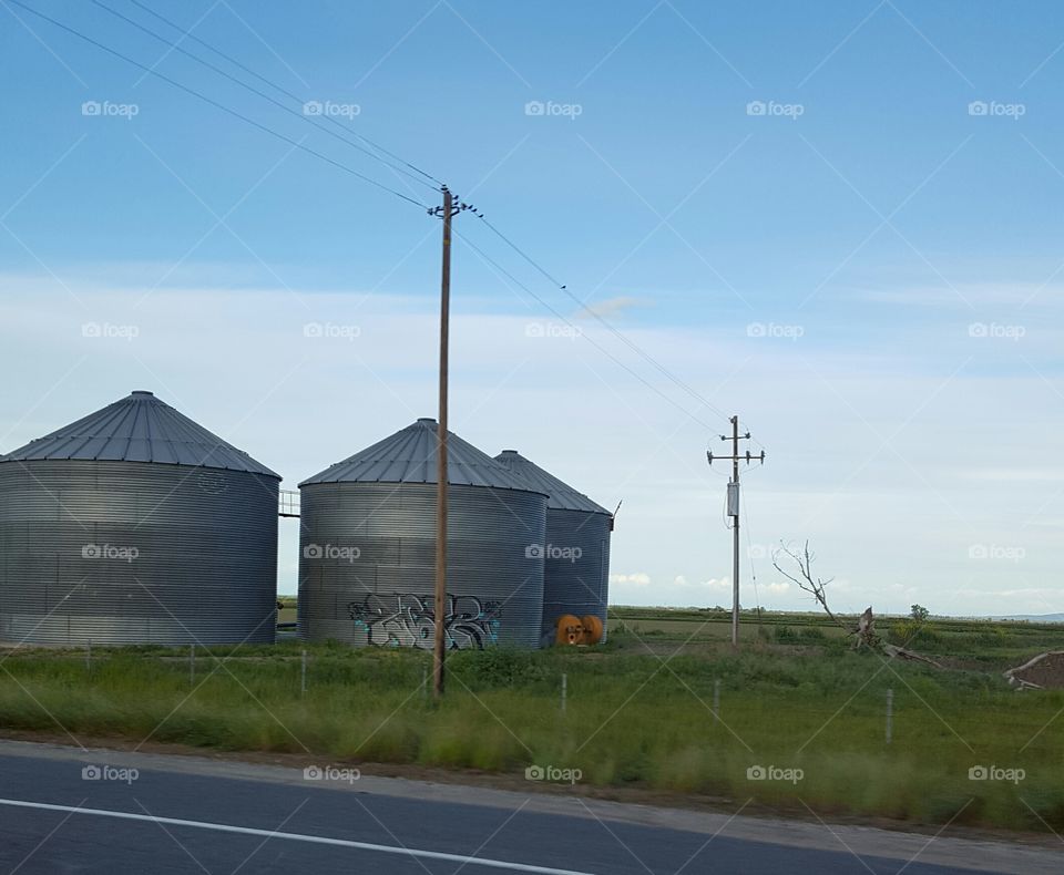 on the road . graffiti on silos.