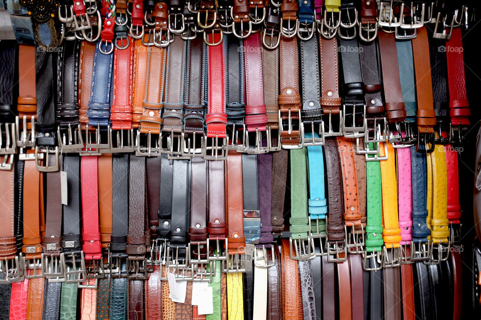 Colorful leather belts on stand