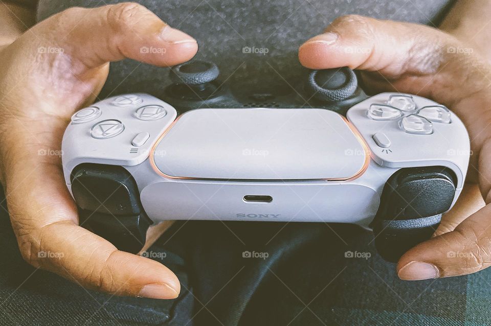 Woman’s hands holding gaming controller, hands playing PlayStation 5, person gaming at home, using a game controller, PlayStation five game controller 