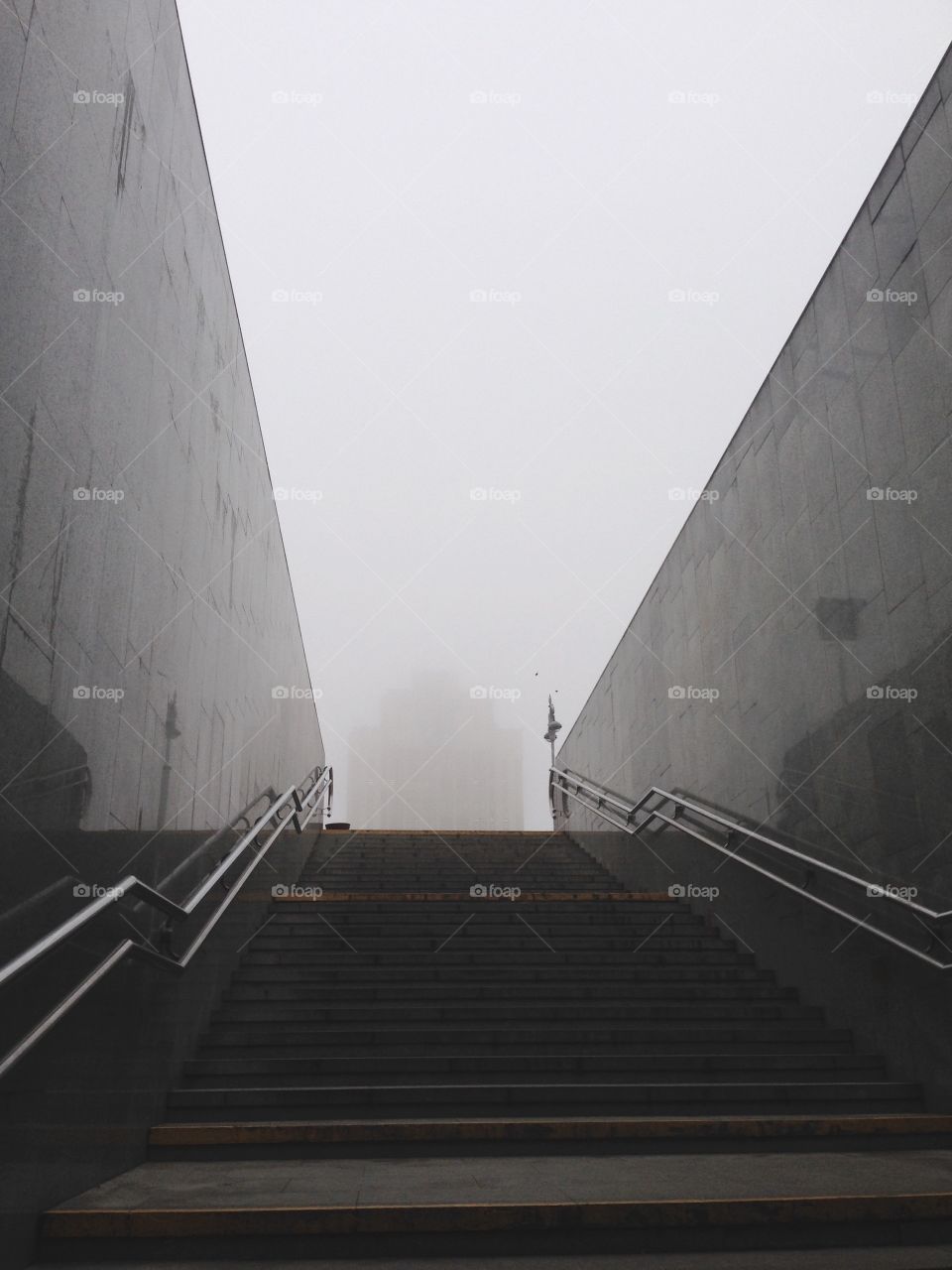 Exit from metro station, stairs going up and building in fog 
