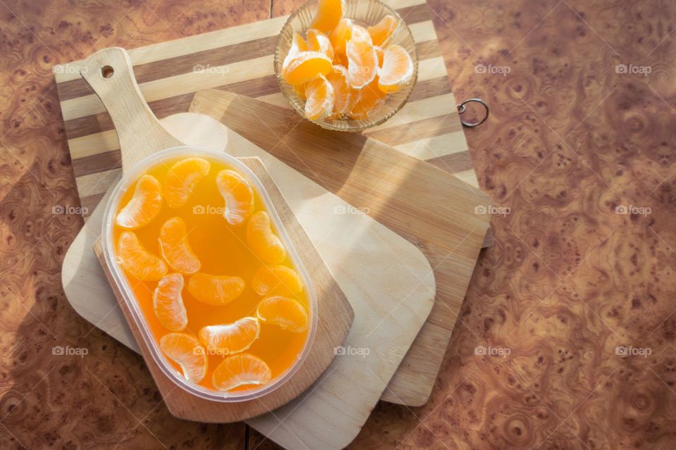 Delicious orange jelly with tangerine slices in a container and jelly worms.