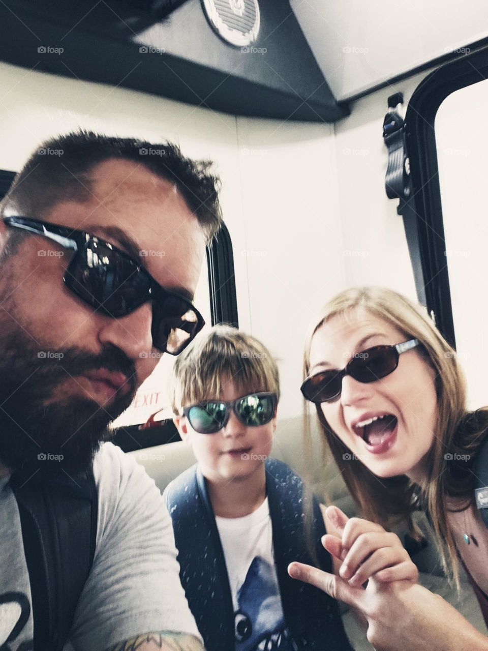 Selfie of a young family of three riding on a bus