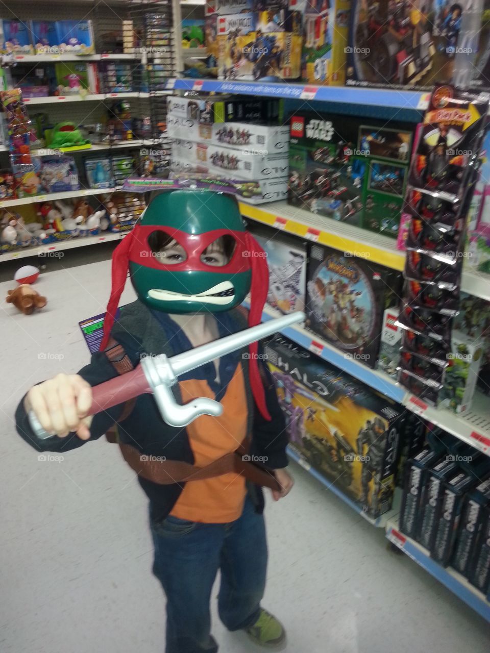 Young boy trying on a costume in the store. He is quite happy and looking cool.