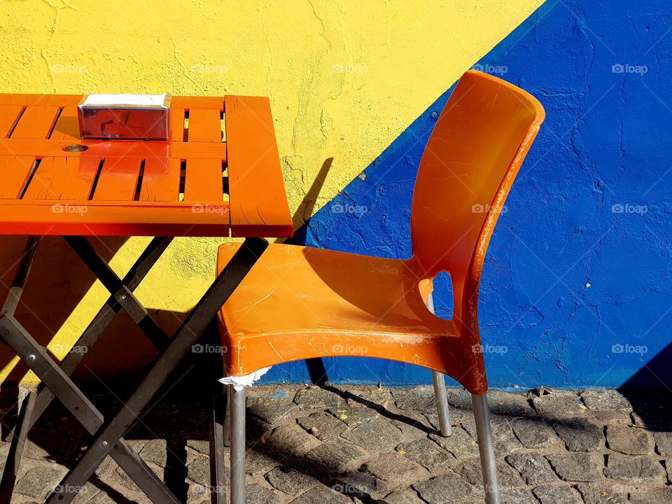 orange chair and table against a blue and yellow wall