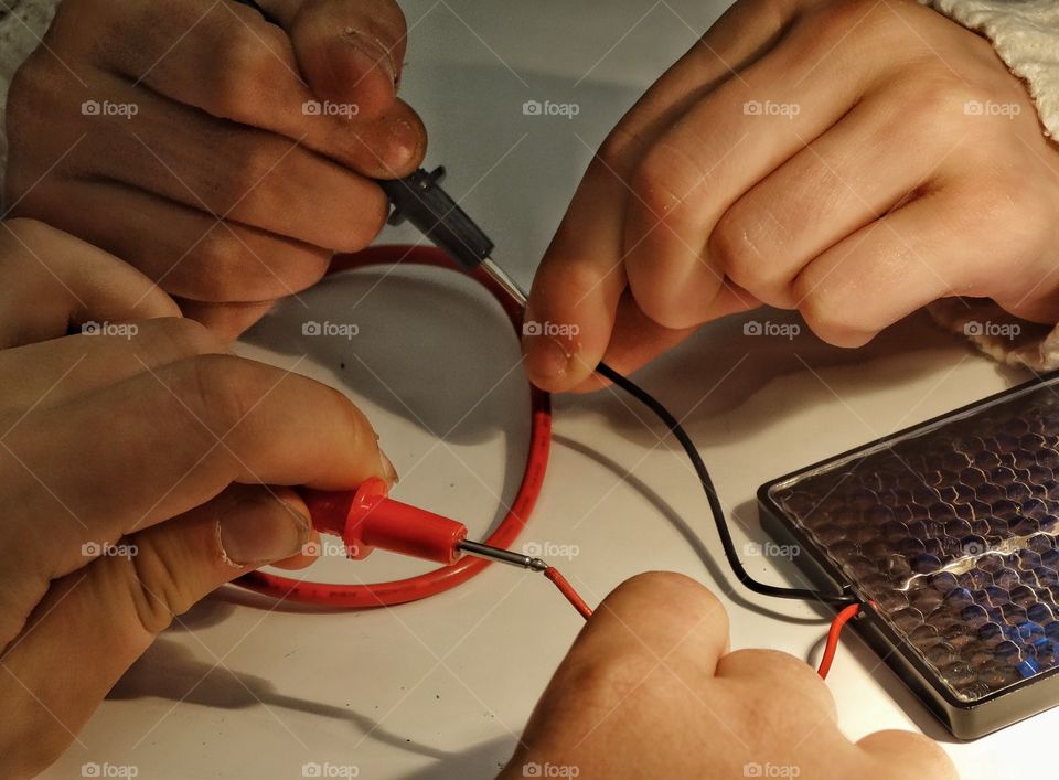 Building An Electrical Circuit. Young Hands Assembling Electrical Wires Into A Circuit For A Classroom Science Project
