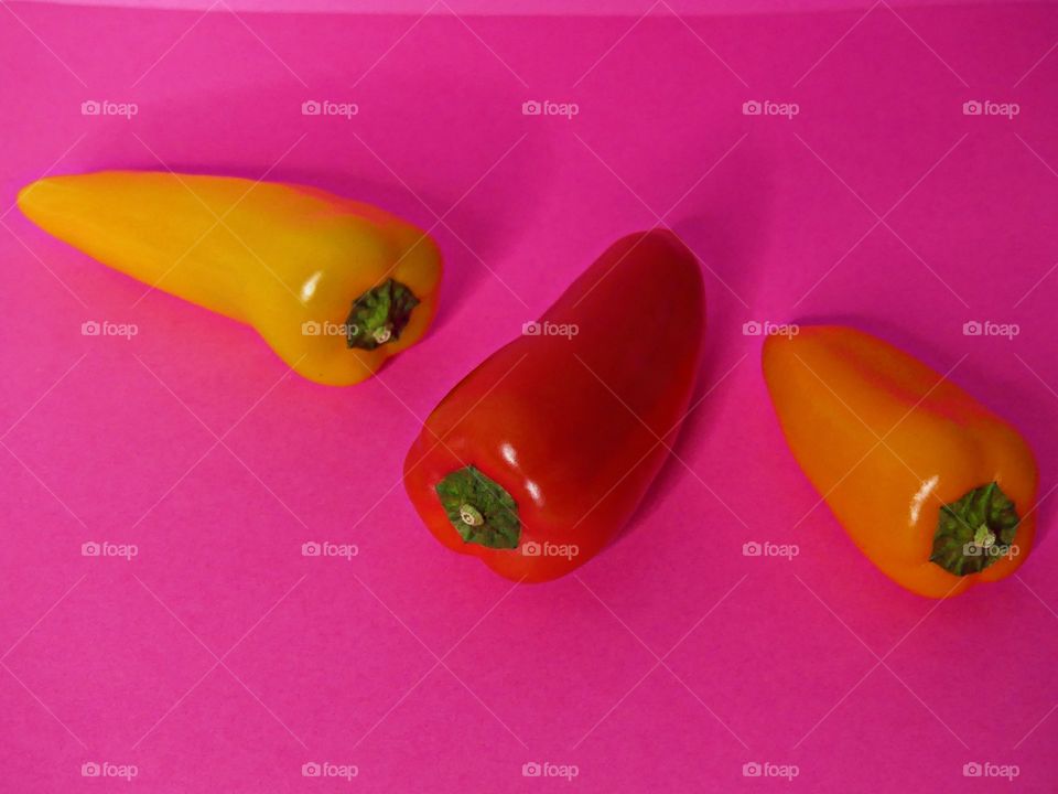 Three colorful peppers - The Power of Threes - Everything that comes in threes is perfect, or, every set of three is complete, conveys the same idea as the rule of three. Displayed on Bright, colorful backgrounds.