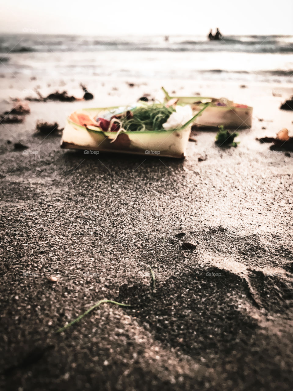 Bali Indonesia, the offerings to Gods, placed by a local balinese on the beach in the afternoon, close to sunset time