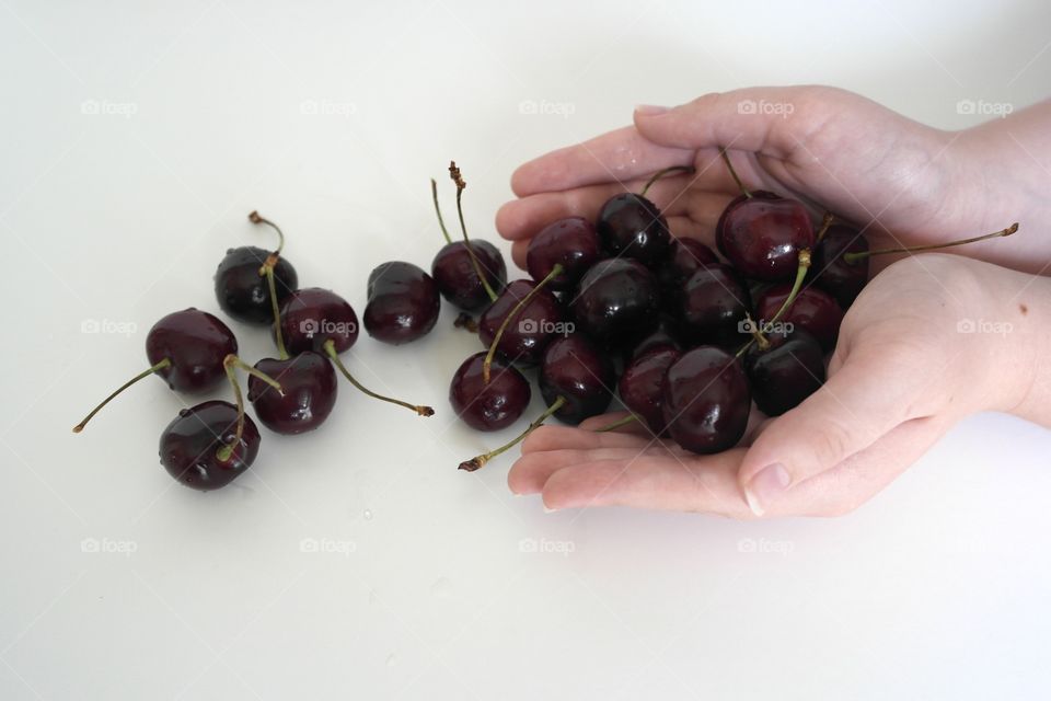 Hands holding cherries 