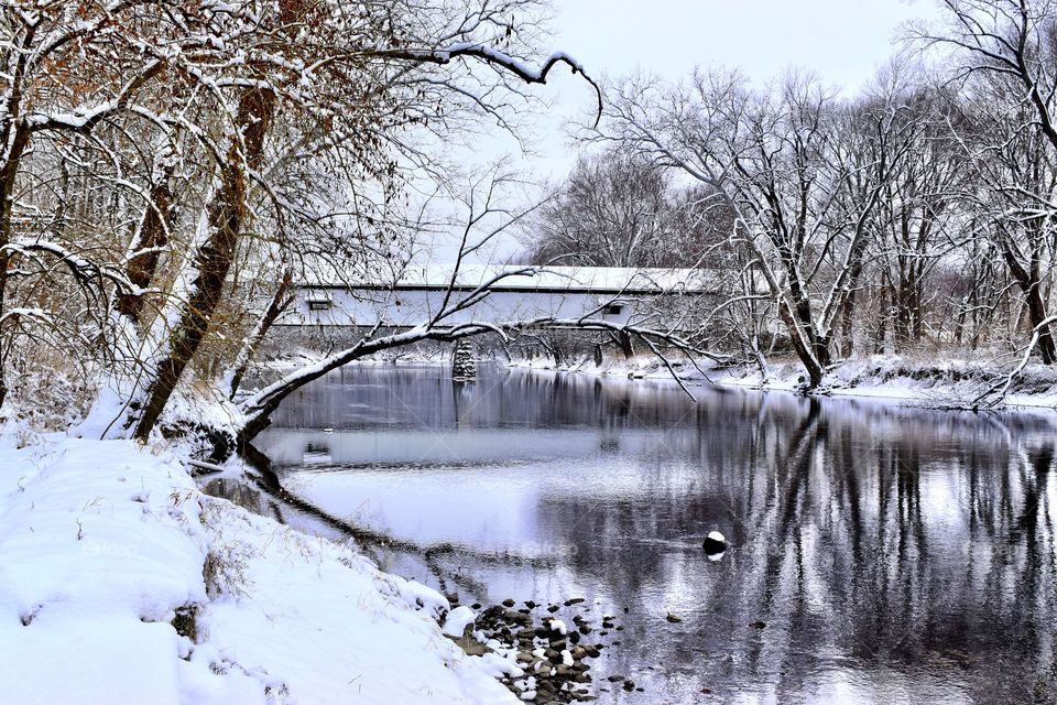 A beautiful landscape on a snowy day in Indiana of the old covered bridge on the white river 