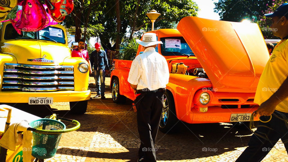 Homens e veículos antigos de coleção. Cores vibrantes, amarelo e laranja.