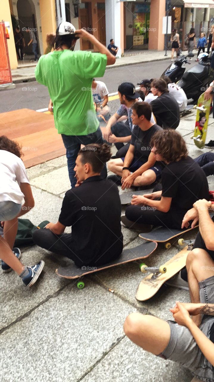 Group of friends on sidewalk with skateboard