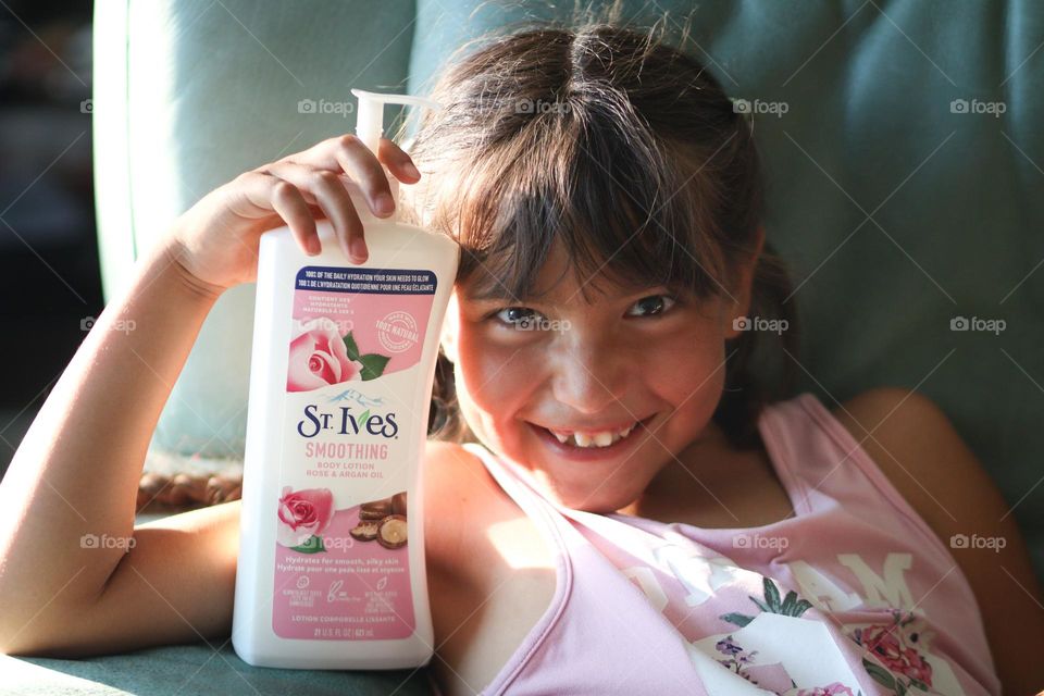 Happy smiling cute girl with St.Ives care product