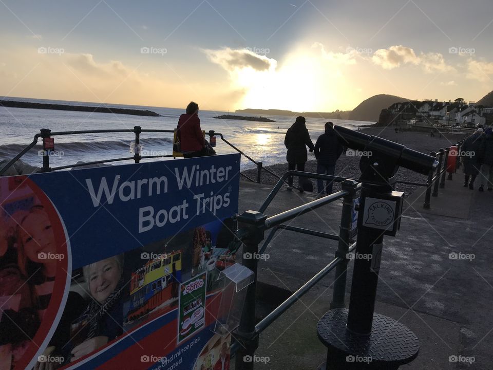 Many people admiring the sunset and wave watching.
