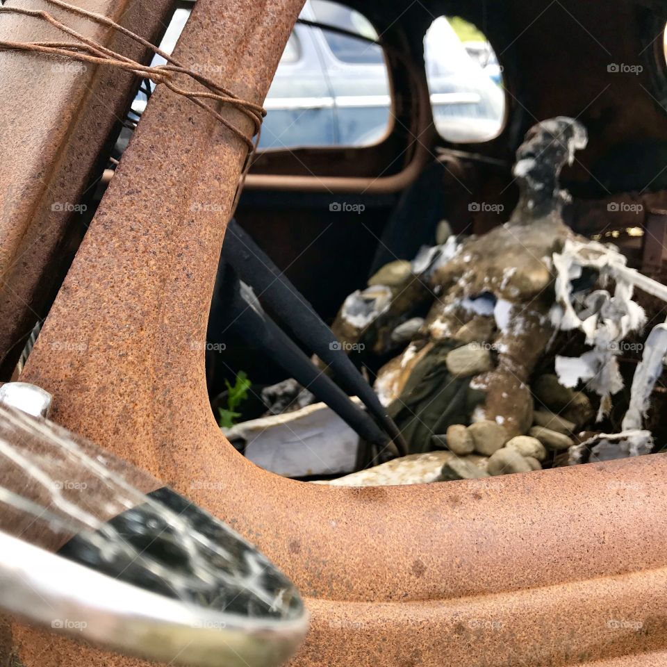 Vintage car rusted with mannequin 