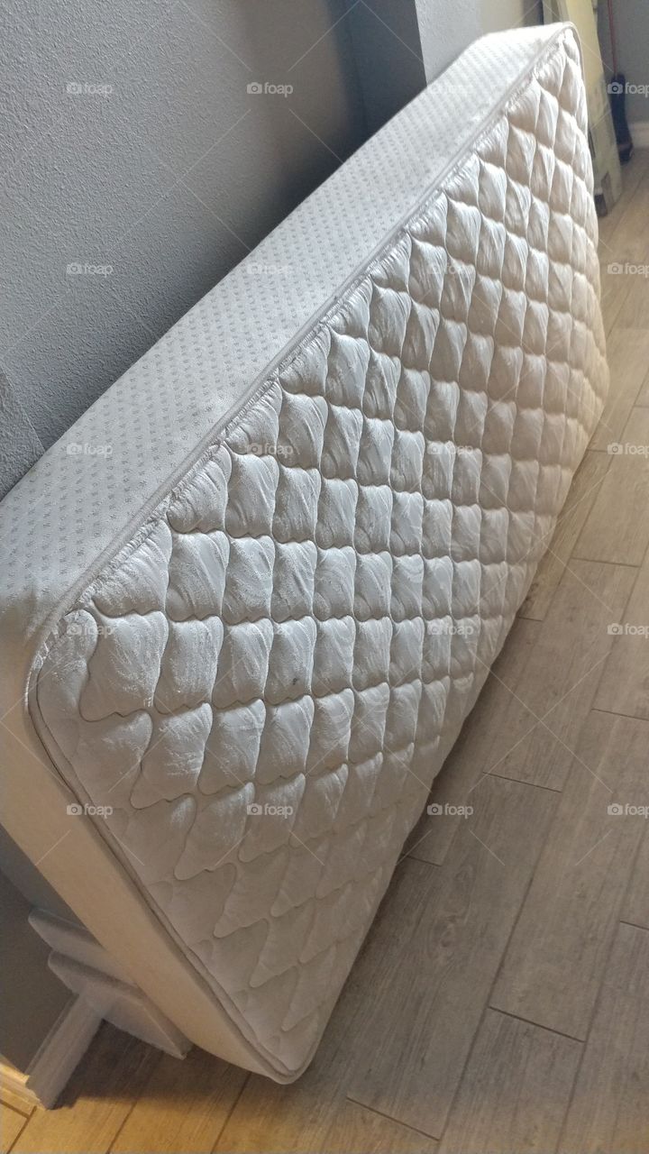 Twin mattress leaned against a wall.