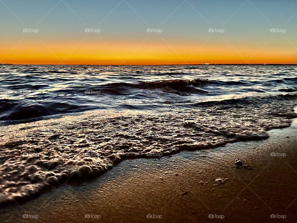 A breathtaking and radiant sunset which colors the waves iridescent, often towers and collides the shore with great force. The impact of the waves against the coastline created a stunning display of energy and motion