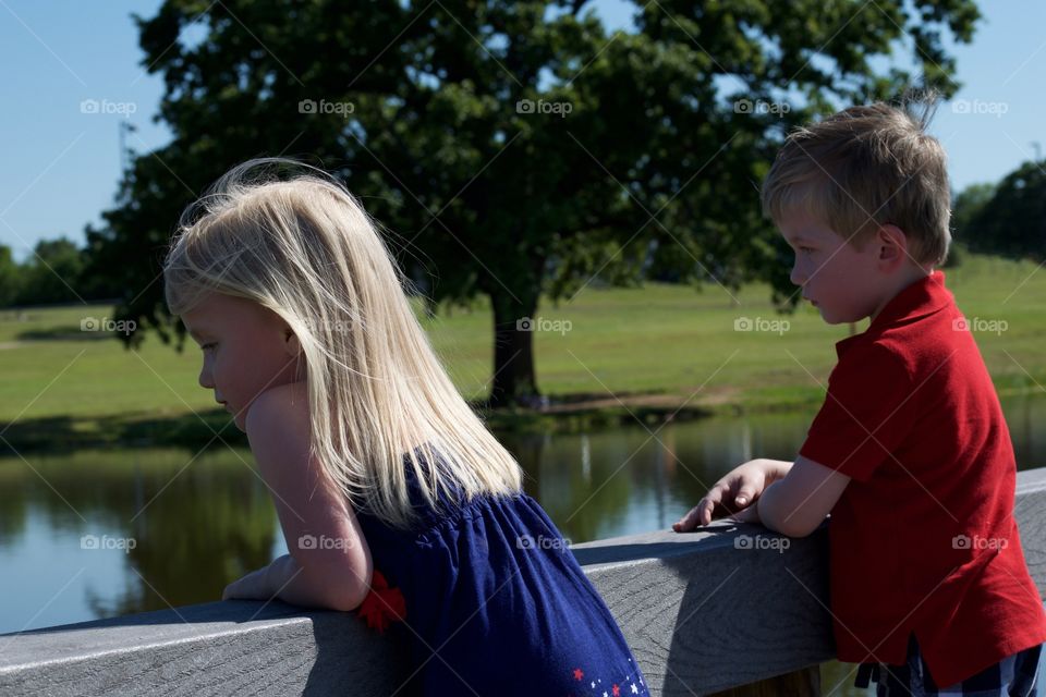 Twins looking at a pond