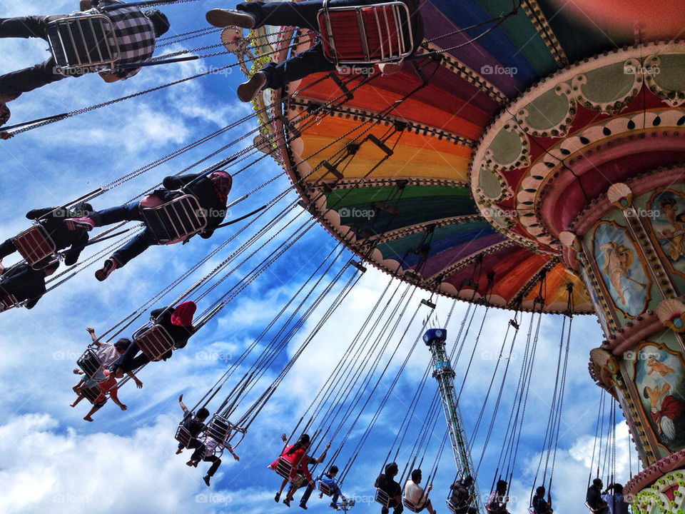 Low angle view of people on swing in carousel