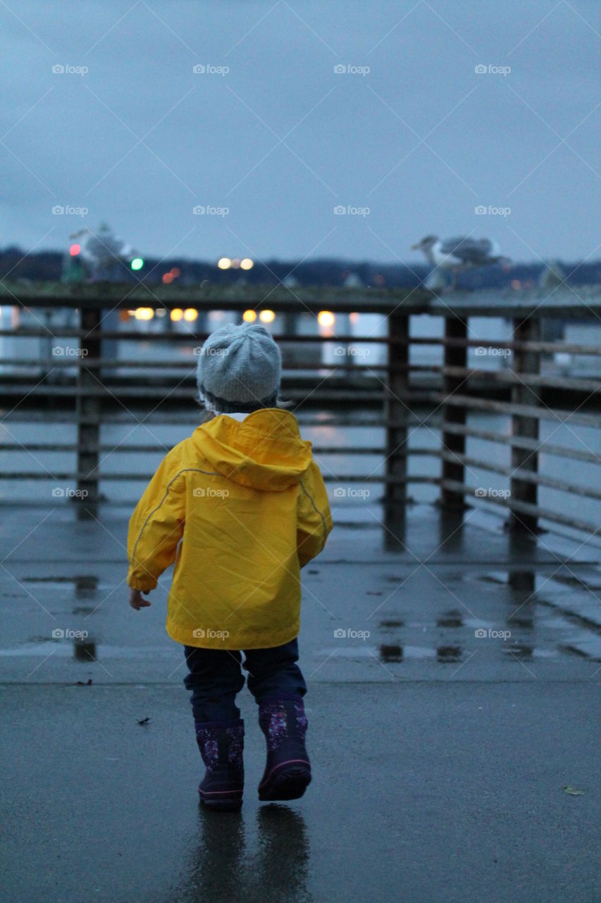 Rear view of boy walking on rail