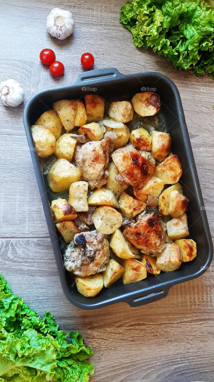 Baked chicken with potatoes and garlic.