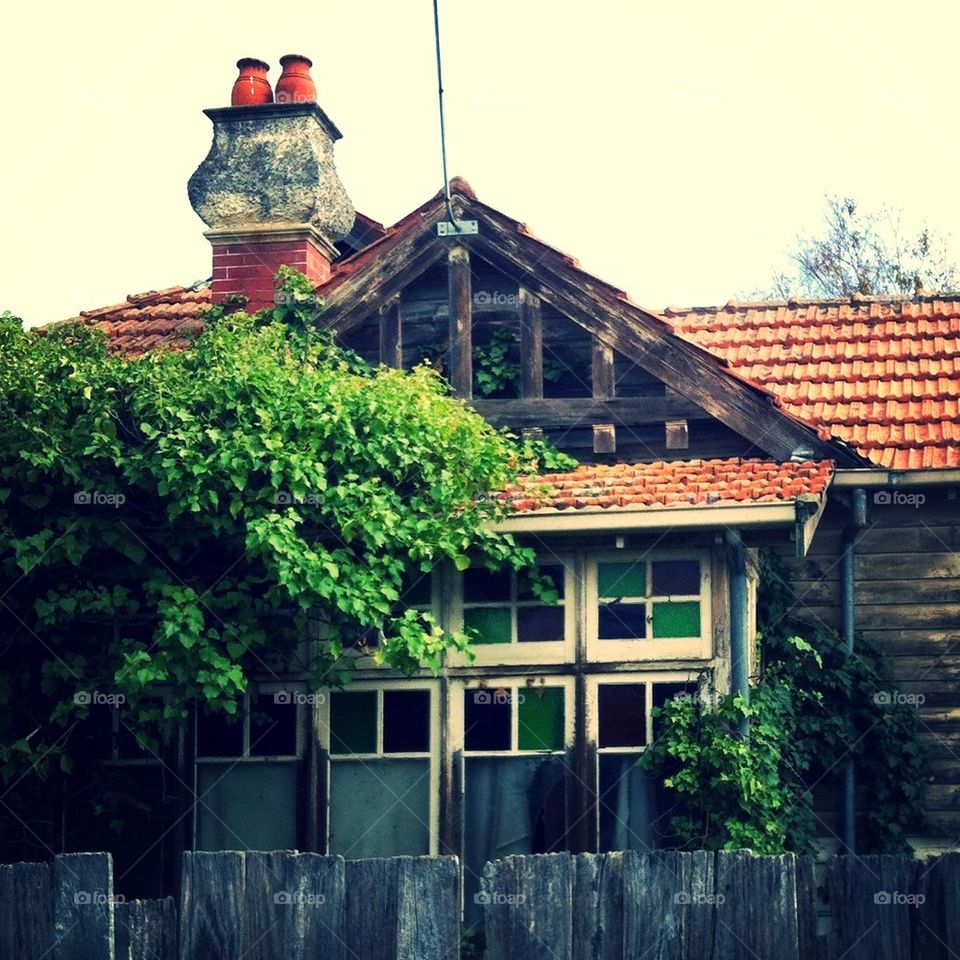 Charming little run-down wooden house in suburbia, featuring