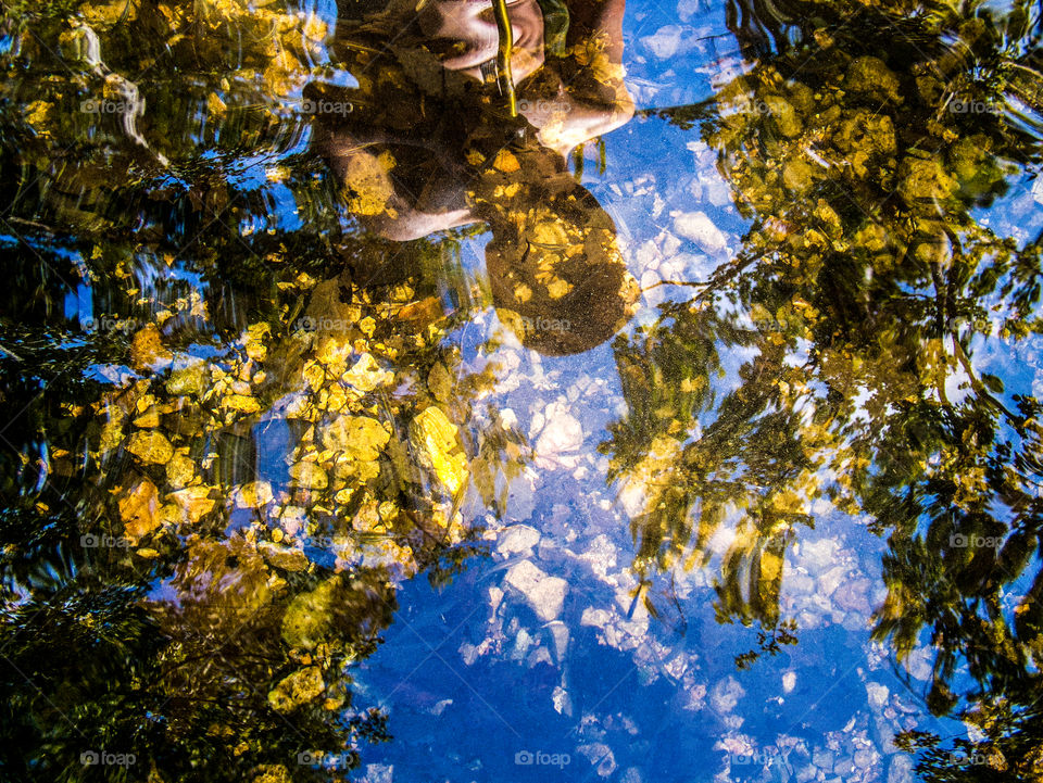Stream reflections . Image of a young hiker reflection in a clear ozark stream.