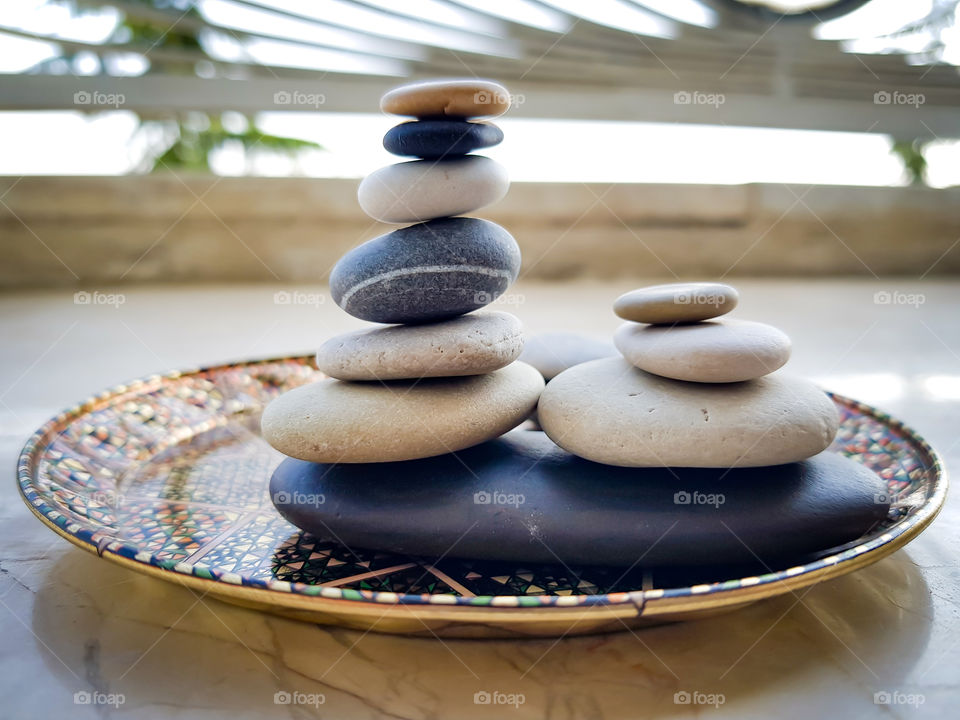 colourful pebbles arranged balancing on a beautiful plate