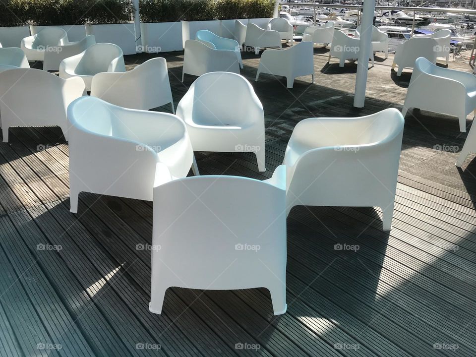 white chairs on a pier of a marina in Portugal