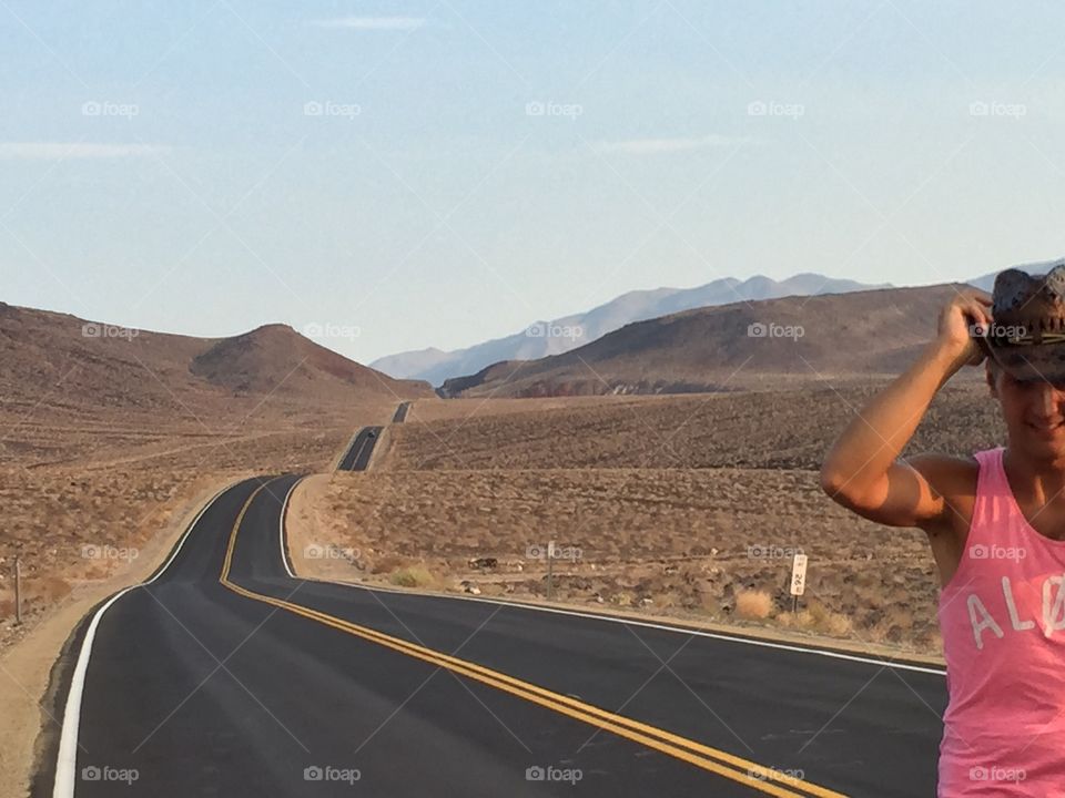 Man standing on highway at mountain