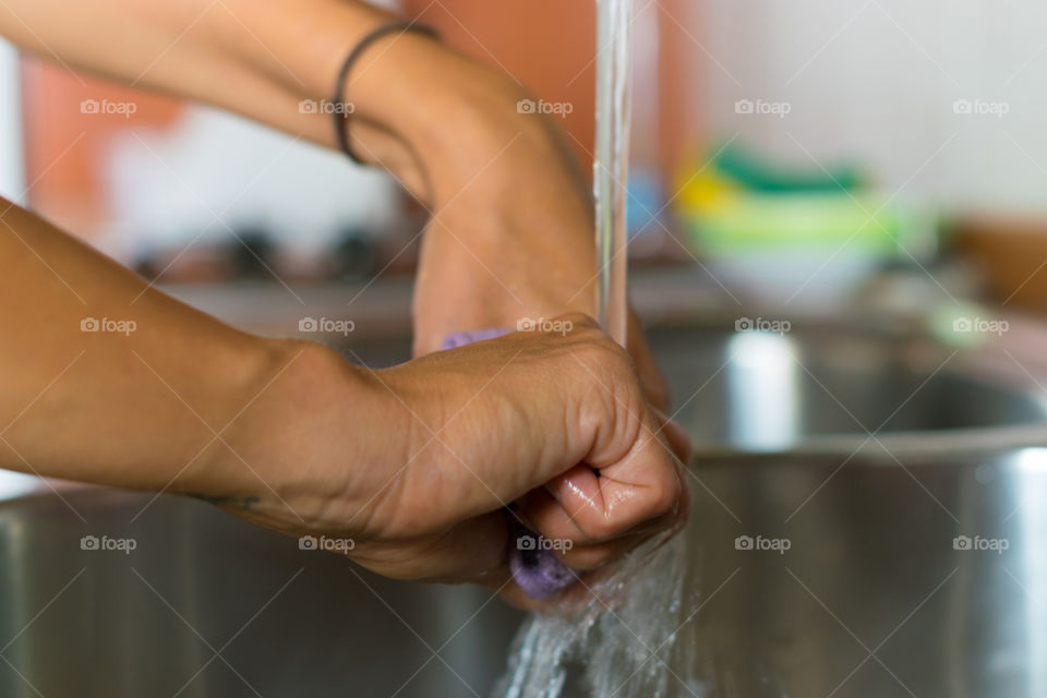 Close-up of human hand washing cloth