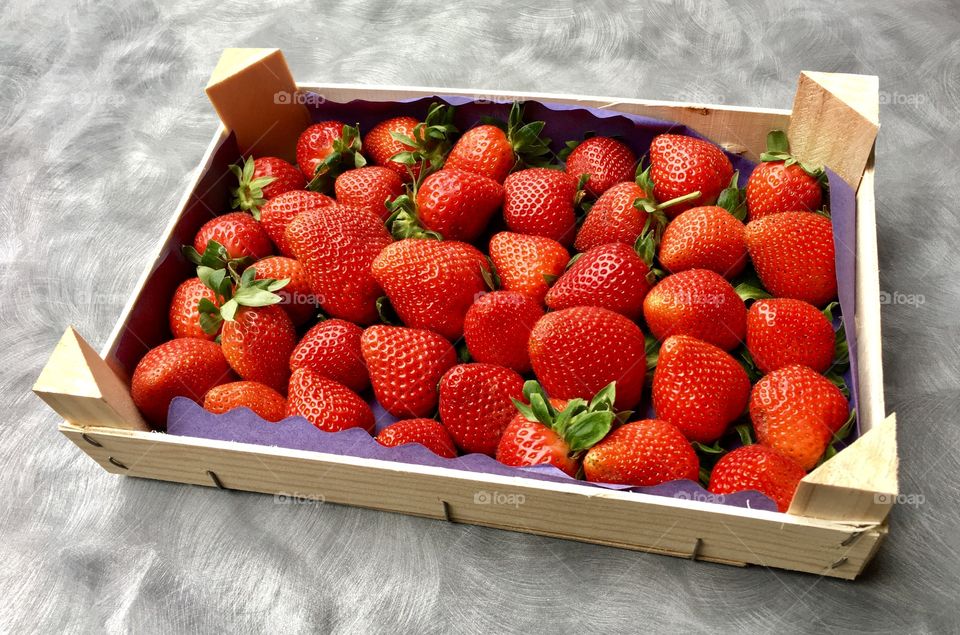 strawberries in a fruit mini-box  on a mottled gray base