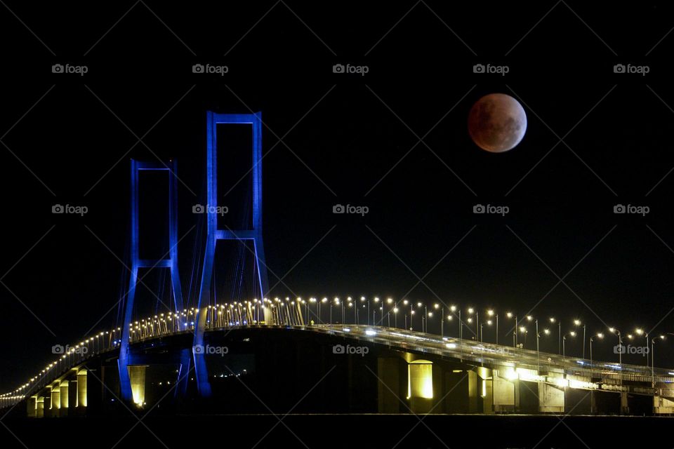 the red moon is visible over the Suramadu bridge at certain moments