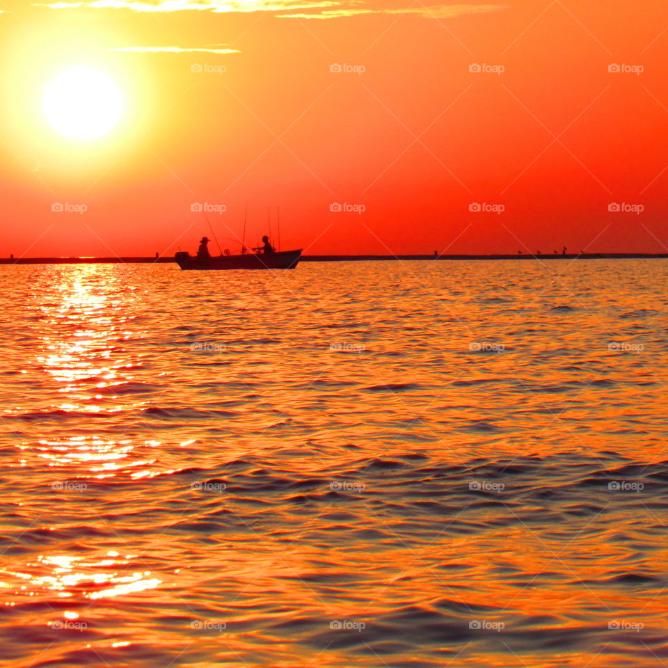Sunset over Lake Michigan with fisherman 