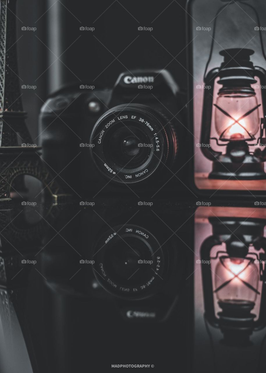 Classic dslr on the table together with Eiffel Tower and Lantern Light in Phone. 