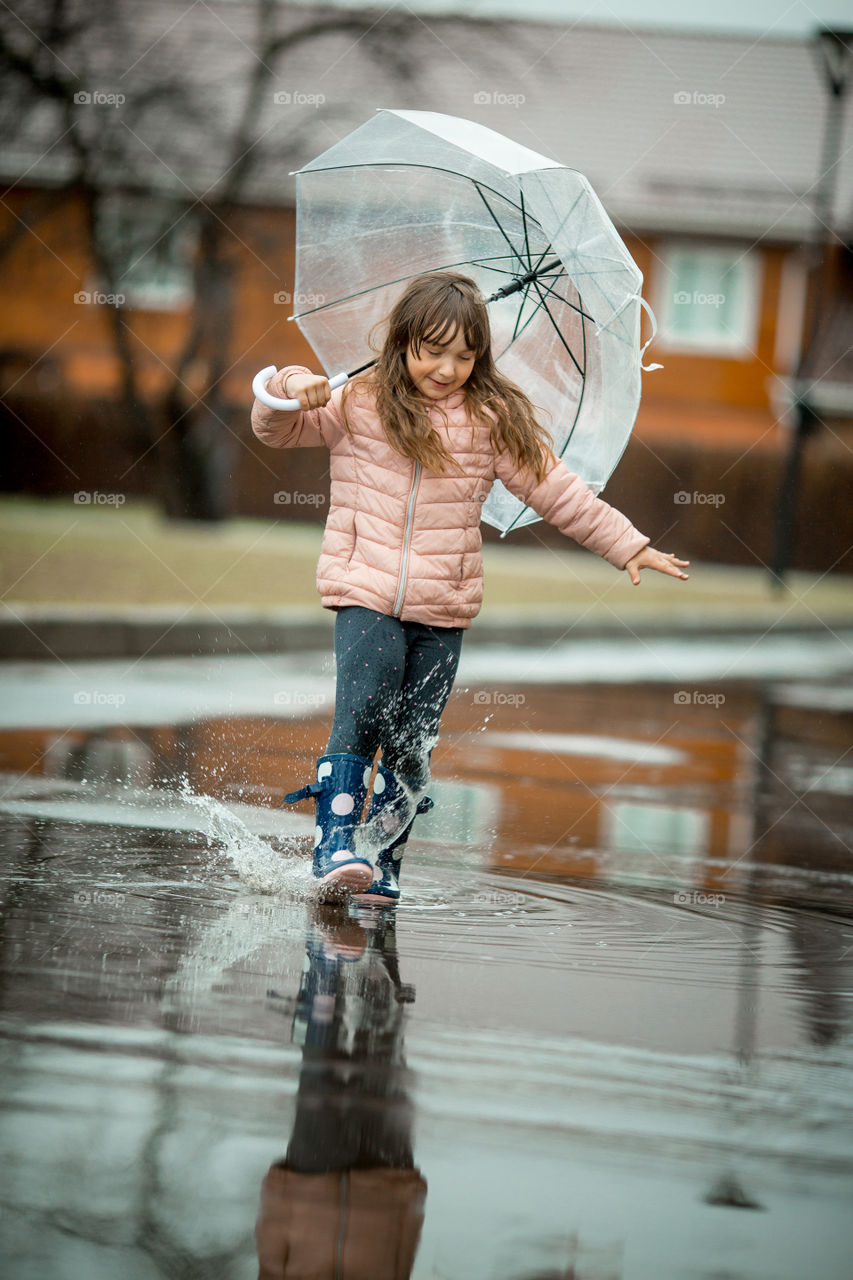 Little girl have fun under the rain.