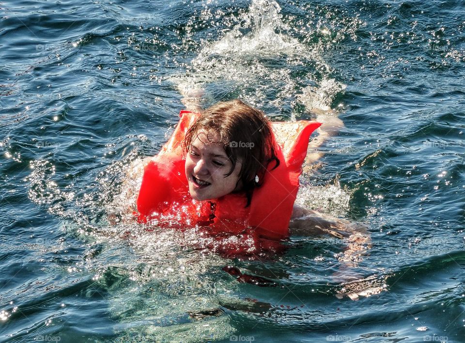 Girl Swimming With A Life Preserver
