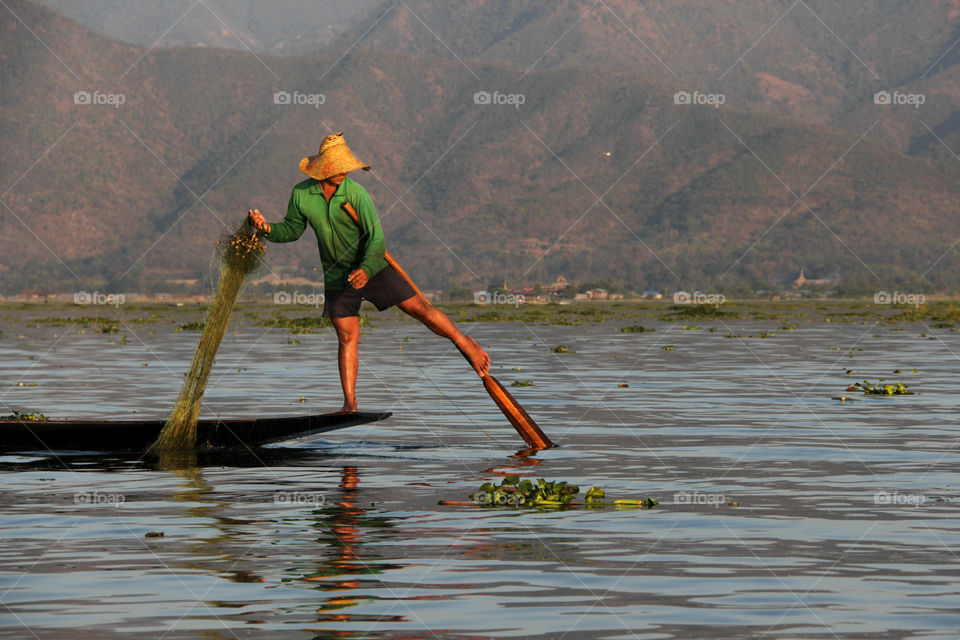 The fishermen of Inle lake use their feet to steer the boat across the water 