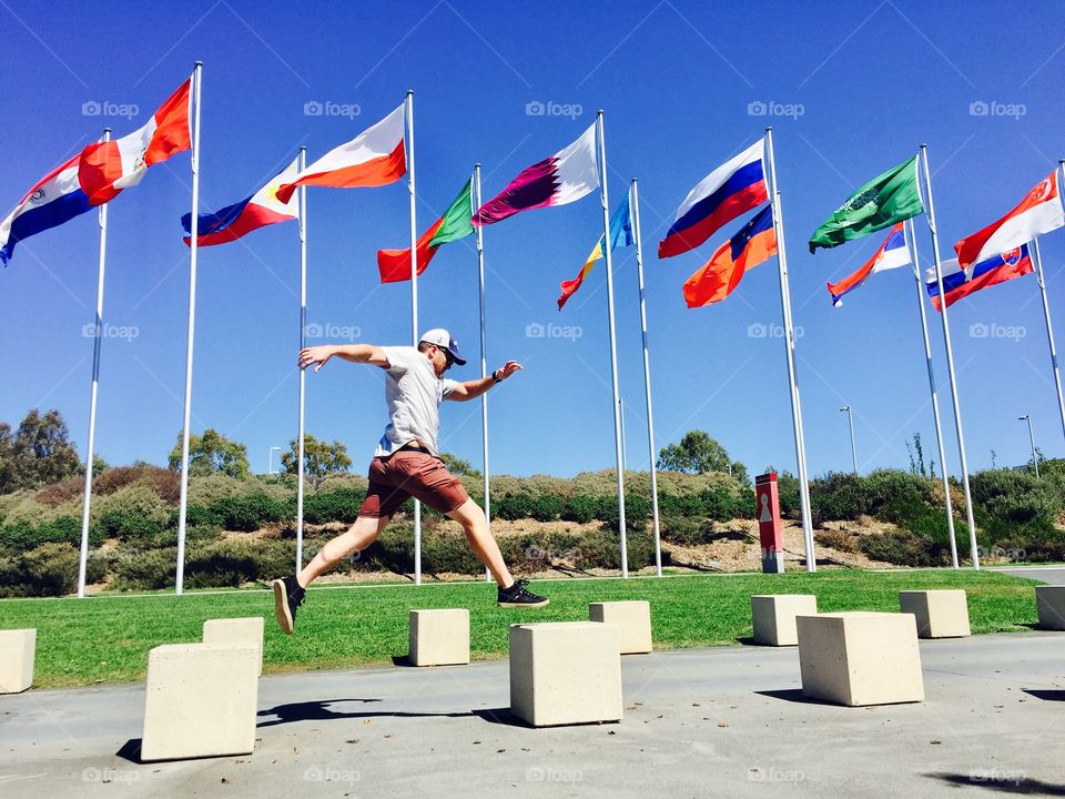 Man jumping in air across flags
