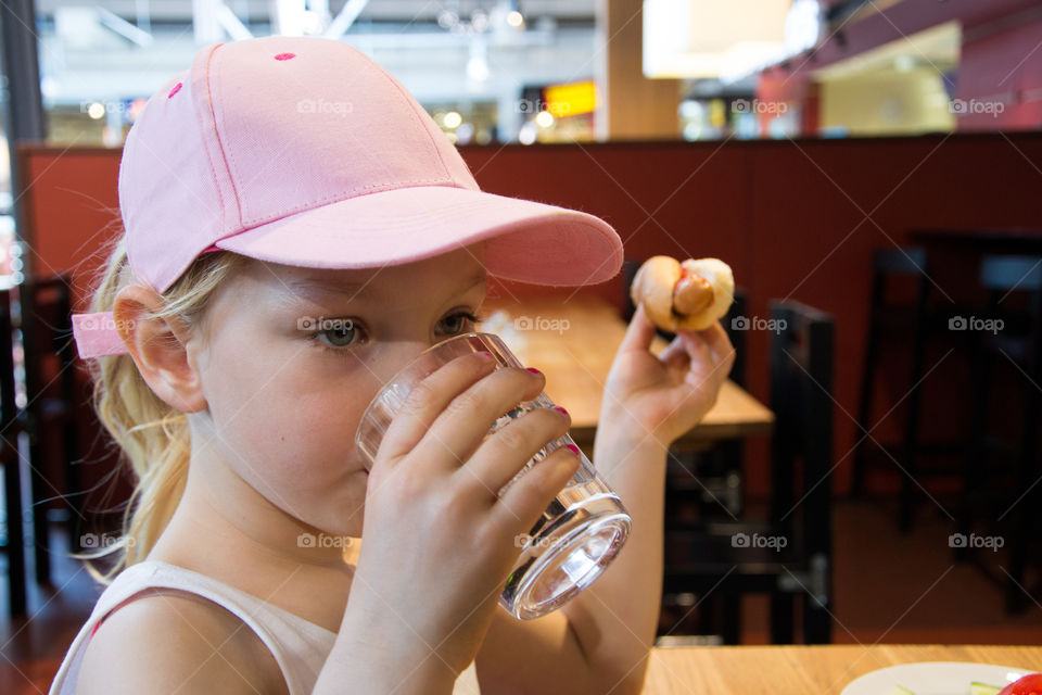 Young girl eating lunch at a shopping mall Mobilia in Malmö Sweden.