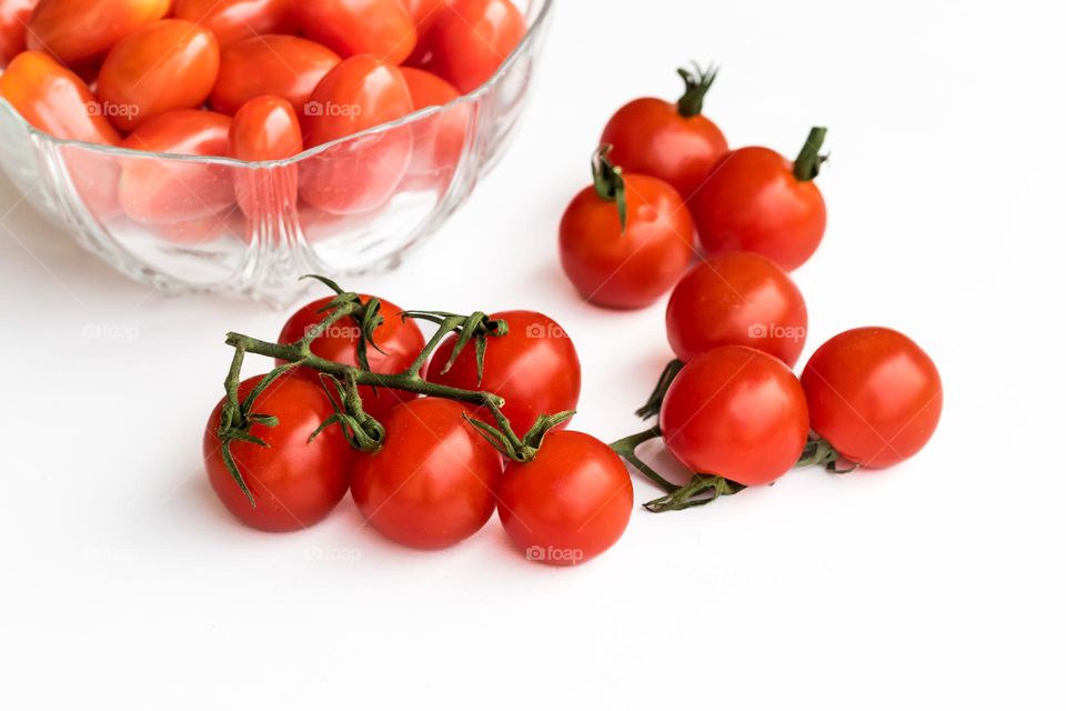 Tomatoes in a glass bowl and on a white plate 