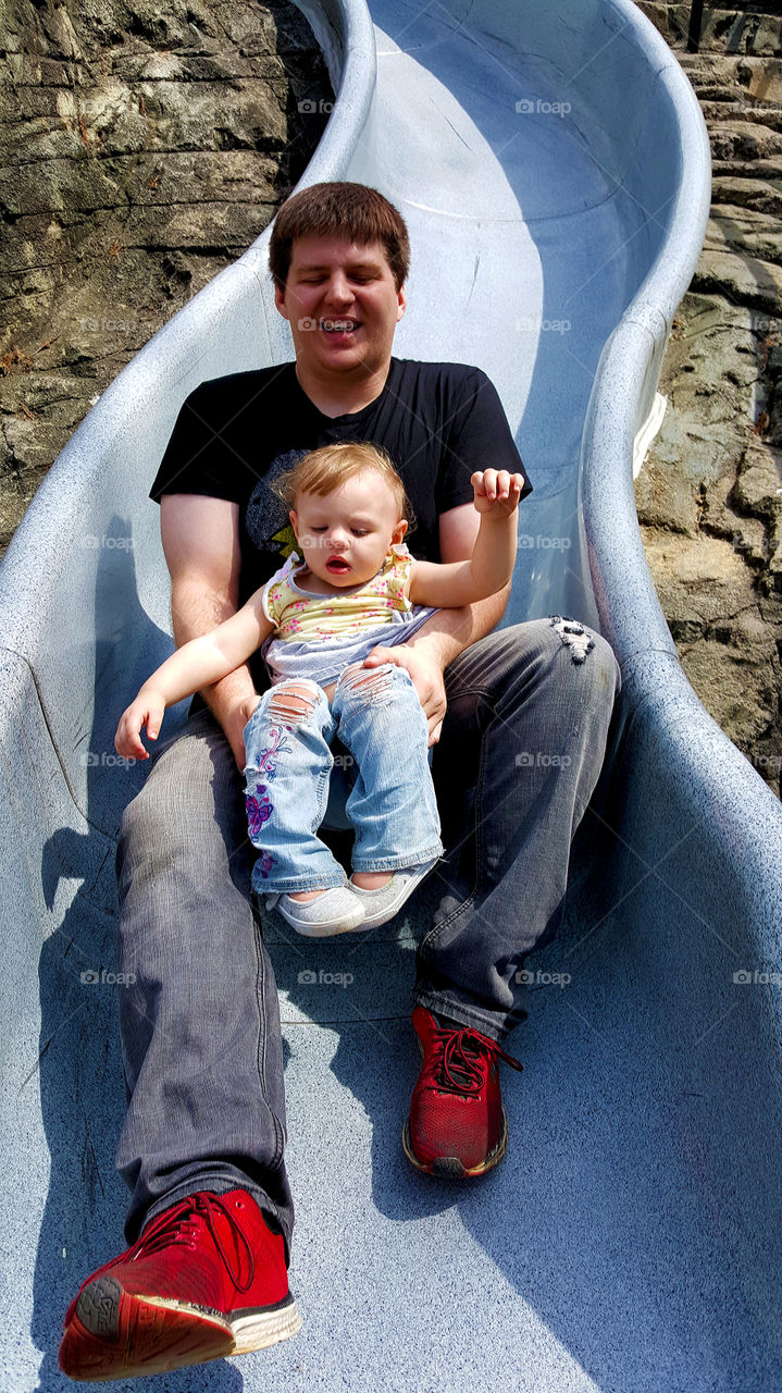 Father and son playing on slide