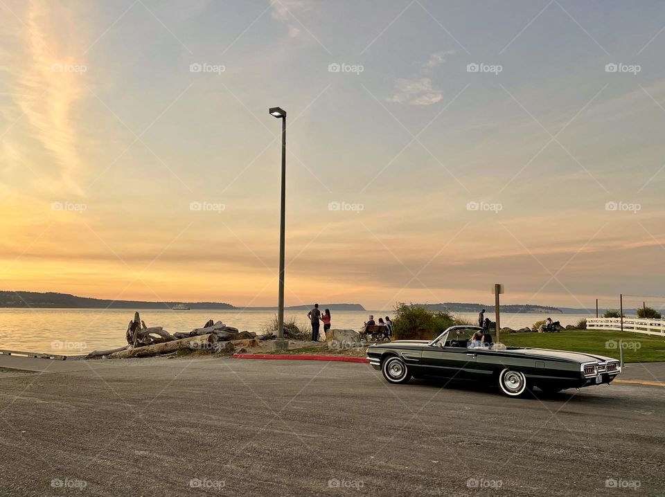 Black retro cabriolet on the sunset beach 