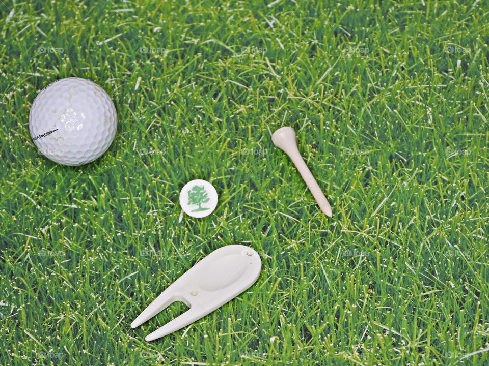 White vs Green - Green blades of grass and white Golf accessories for a great day on the greens