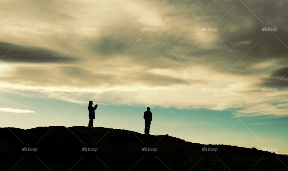 Silhouettes of two men in the mountain